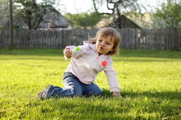 Niña jugando hierba tubo crema pueblo — Foto de Stock