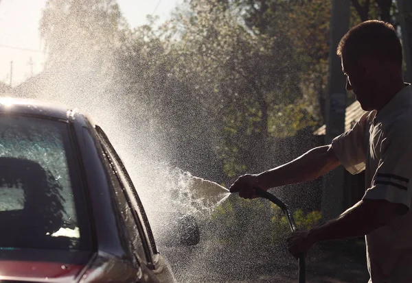 Hombre lava coche manguera gran cabeza spray — Foto de Stock