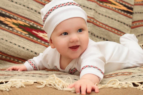Baby uśmiechający się leżącego garnitur kapelusz tle ornament — Zdjęcie stockowe