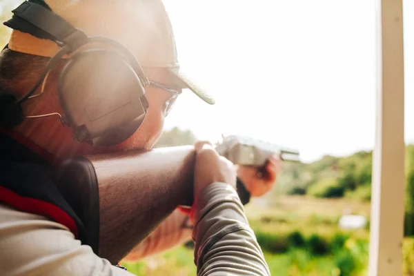 Снайпер стреляет из дробовика летящих целей снаружи — стоковое фото