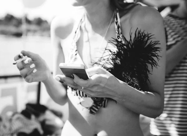 girl swimsuit near water smokes enjoys smartphone