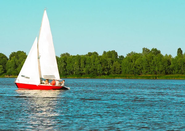 Yacht sailboat moves along water crew raised sail — Stock Photo, Image