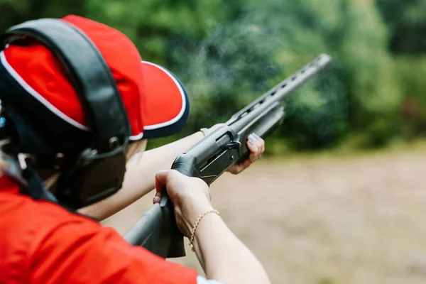 Женщина стрелок наушники стреляет охотничий дым ружья выстрел — стоковое фото