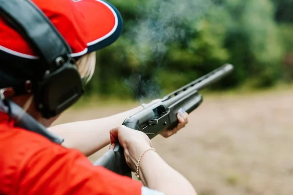Женщина стрелок наушники выглядит результат выстрел охотничья винтовка — стоковое фото