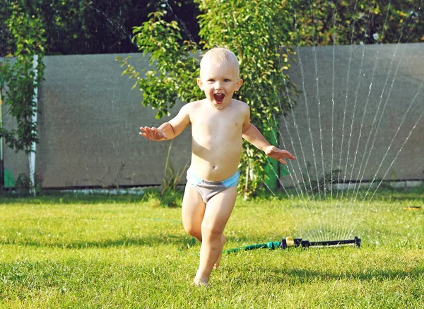 Chłopiec biegnie boso trawy od wody emocje — Zdjęcie stockowe