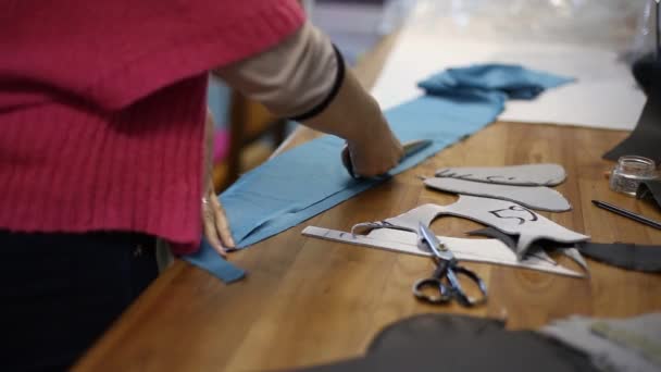 Швачка жінка вирізає заготовки візерунки фігурної майстерні — стокове відео