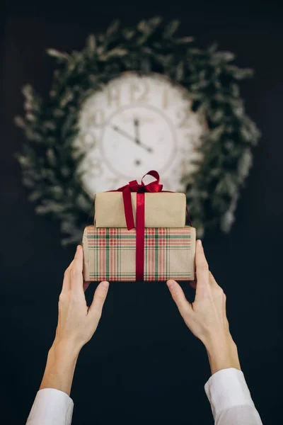 Kerstcadeaus dozen linten handen klok krans — Stockfoto