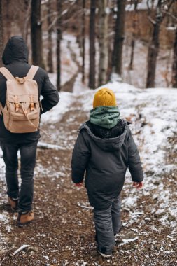 Baba oğul kışın sırt çantasıyla dolaşır.