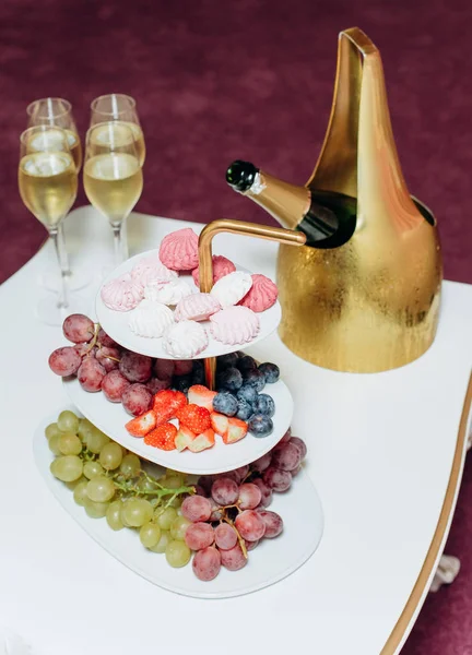 水果葡萄棉花糖彩色桌子，装香槟 — 图库照片