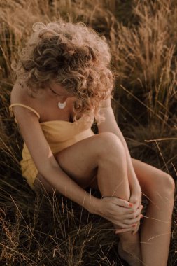 woman curly hairstyle outside field freedom sunset