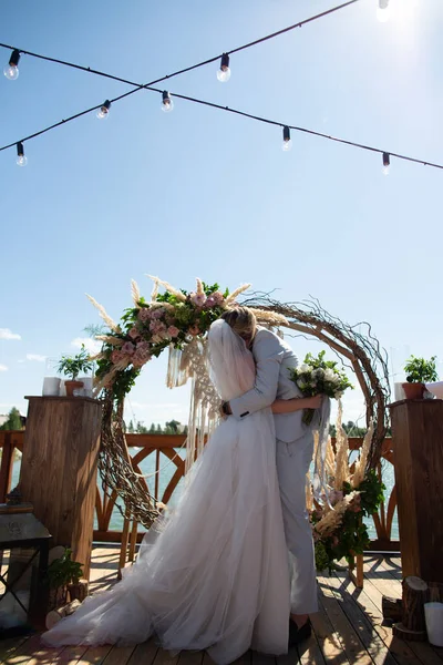 恋爱中的夫妻亲吻新郎 拥抱婚礼拱门 — 图库照片