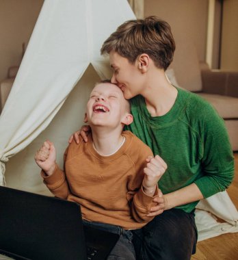 Anne ve oğlu dizüstü bilgisayarda internet eğlence odası çocuk kulübesine bakıyorlar.