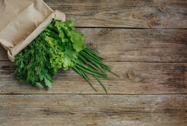 Taze sebzeler ahşap arka planda sol tarafta. Yazıtlar için boş bir yer.