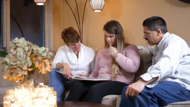 Famiglia Guardando Vecchie Foto Dell Annuario Sul Divano Soggiorno — Video Stock