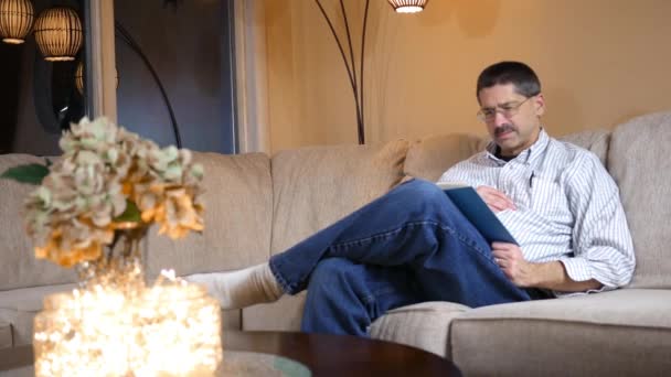 Homem Caucasiano Sofre Ataque Cardíaco Sofá Enquanto Livro — Vídeo de Stock