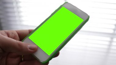 Yeşil ekran Smartphone ortam pencere Panjur yakınındaki holding