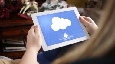 Kadın tablet rustik salon içinde belgili tanımlık bulut için dosyaları indirmek için kullanır