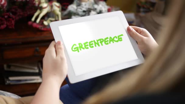 Γυναίκα Κοιτάζει Στο Tablet Λογότυπο Της Greenpeace Στην Screeneditorial Χρήση — Αρχείο Βίντεο