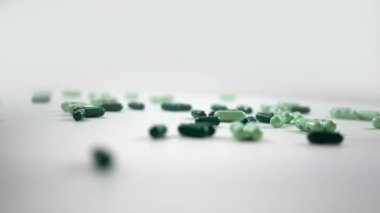 Açık ve koyu yeşil vitamin hap kapsül üzerinde beyaz iplik 