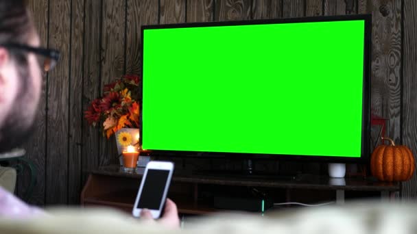 Millennial Männlich Auf Dem Smartphone Während Generische Green Screen Wohnzimmer — Stockvideo