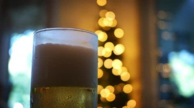 Noel zamanı çevresinde bir bira bardağı içinde dolduruyor köpük