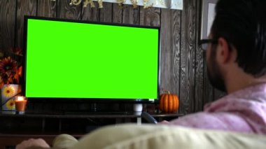 Sıkılmış bin yıllık erkek kanal yeşil ekranda Tv uzaktan ile sörf