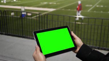 Adam yeşil ekran Tablet bir futbol takımı Alıştırma oturumu tribünün üzerinden, seyreder