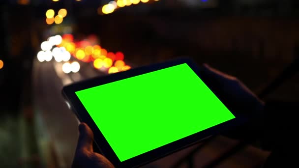 夜の高速道路の近くに緑色の画面タブレットを見てください — ストック動画