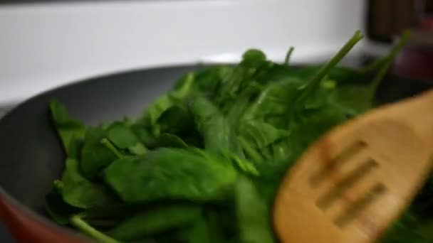 Close Wooden Spoon Stirring Wilted Spinach Heated Pan — Stock Video