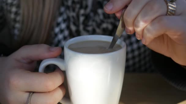 Gros plan d'une femme brassant une boisson au café irlandais dans une tasse sur un dîner branché dans un café 