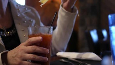 Bir orta yaşlı kadın içinde bir bloody mary alkollü içecek içecekler bar