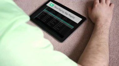 Bir adam bir genel sahte app çalma listesine onun tablet - Rap Version dinler.