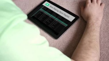 Bir adam genel sahte app çalma listesine onun tablet - Rock sürümü dinlemez.