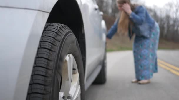 Mujer Inspecciona Neumático Pinchado Dañado Parte Trasera Suv Carretera — Vídeo de stock