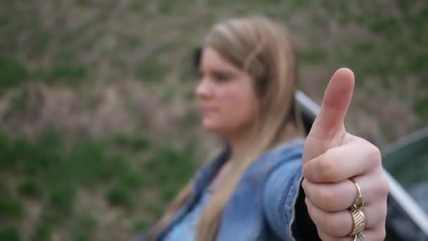 ヒッチハイクしている女性がカメラまで親指を与える — ストック動画