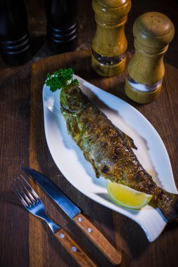 Limon ve beyaz tabakta maydanoz fırında uskumru