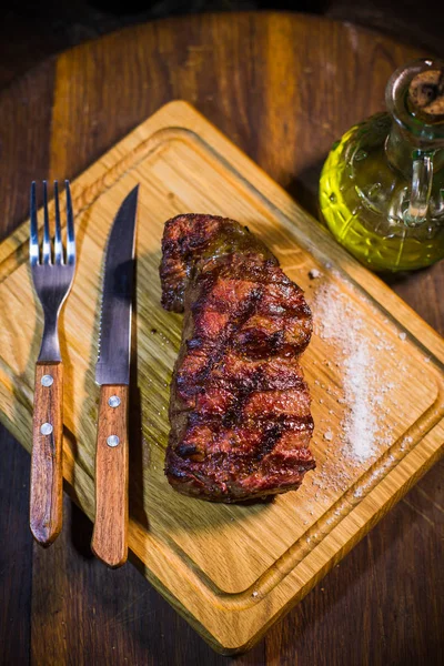 Соковитий середній стейк з яловичини Ребро Око на дерев'яній дошці з виделкою і ножем — стокове фото