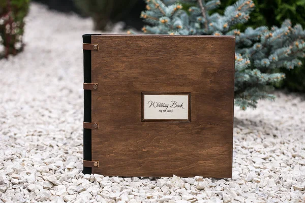 Fotobuch aus Holz. Hochzeits-Fotoalbum mit Holz- und Ledereinband ist auf einem Steinhintergrund in der Natur — Stockfoto