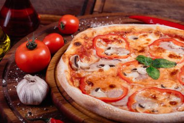 Biberli, mantarlı ve ahşap tepside jambonlu iştah açıcı pizza