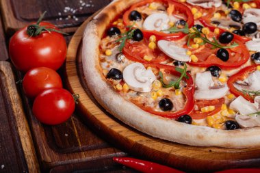 Köy ahşabında dilimlenmiş sebzeli pizza. Eski usul.