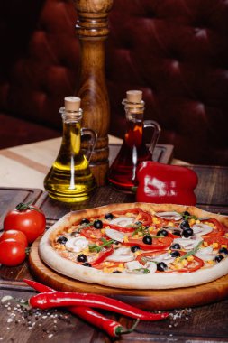 Köy ahşabında dilimlenmiş sebzeli pizza. Eski usul.