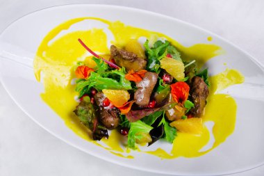 Karaciğer, roka, portakal, ıspanak ve bademle kaplı salata..