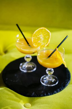 Çekici kadınlar kafeteryada konuşup meyve suyu içiyorlar. Gülümsüyorlar. Tüplü portakal suyu bardaklarına odaklan..