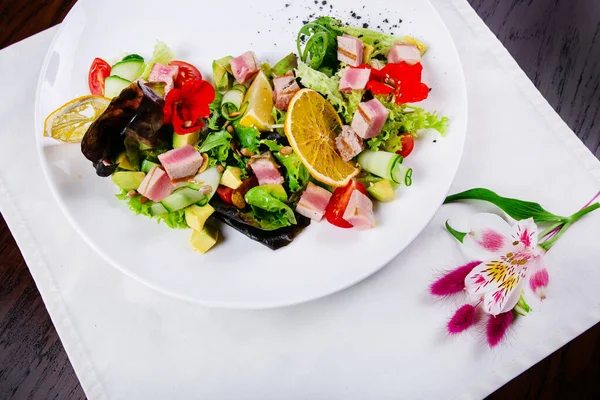 Akşam yemeğinde domates, sosis, jambon, brokoli ve fasulye ile sağlıklı bir salata.