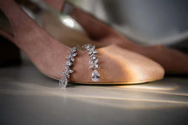 Smycken på en marmor bakgrund med kvinnors bröllop skor på bröllopsdagen. — Stockfoto