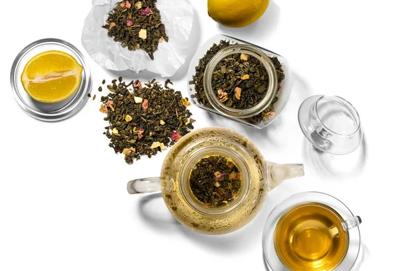 Té, tetera, cuchara y limón sobre un fondo blanco —  Fotos de Stock