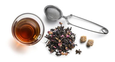 Doğal aromatik katkı maddeleri ve aksesuarlarla siyah çay. Beyaz arkaplanda üst görünüm