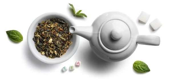 Chá verde com aditivos aromáticos naturais e um bule de chá. Vista superior sobre fundo branco — Fotografia de Stock