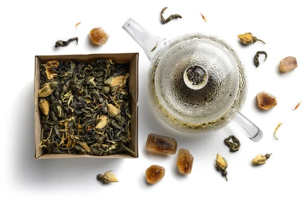 Groene thee met natuurlijke smaken en een theepot. Bovenaanzicht op witte achtergrond — Stockfoto