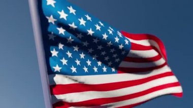 Amerikan bayrağı gökyüzüne karşı rüzgarda dalgalanıyor.